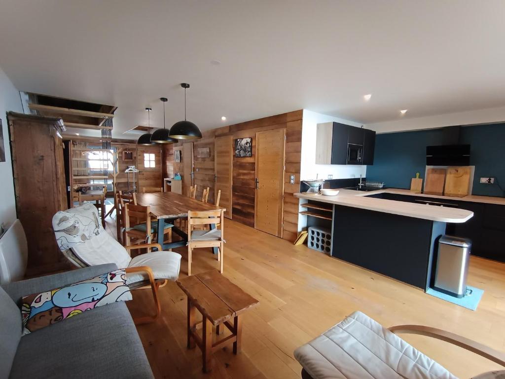 une cuisine et un salon avec une table et des chaises dans l'établissement Chalet luxe refait à neuf, 50m des pistes, garage, terrasse, 125m², 8 pers, animaux acceptés - FR-1-445-192, à Montgenèvre