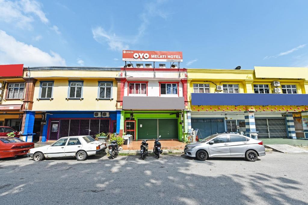 ニライにあるOYO 89656 Melati Hotel Nilaiの建物前に停車する車両群