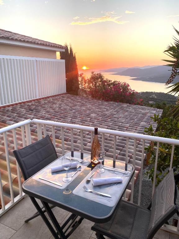 d'une table et de chaises sur un balcon avec vue sur le coucher du soleil. dans l'établissement Charmant appartement 3 étoiles entièrement rénové 