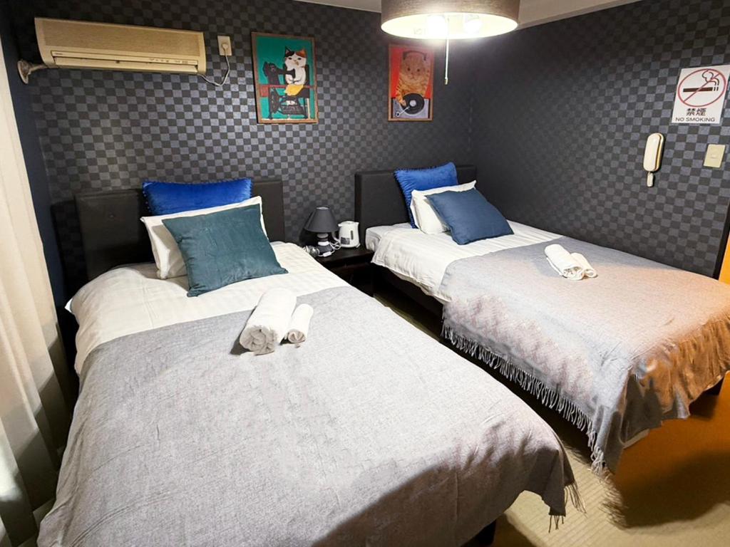 duas camas em um quarto com azul e branco em Asakusa Japanese Style Stay with Futon & Beds em Tóquio