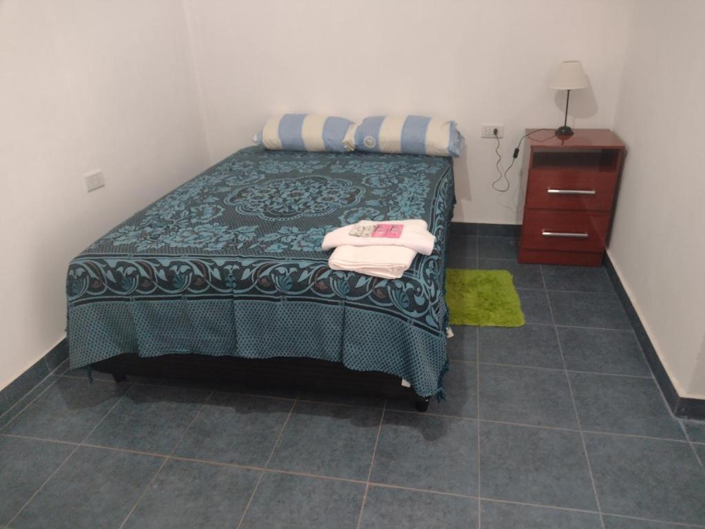 a bedroom with a bed with two towels on it at María del Valle Alojamientos in Belén