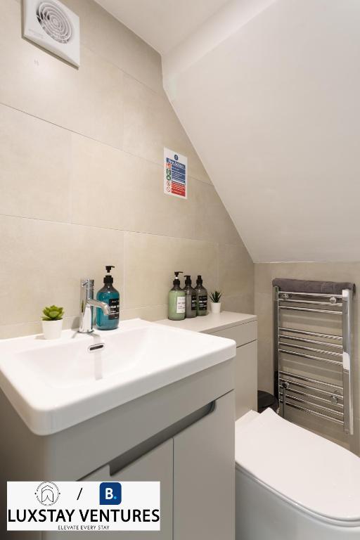 a bathroom with a sink and a toilet at Bright and Spacious 2BR Maisonette Sleeps 8, Game Room, 5 mins to Brighton Beach and City Centre in Brighton & Hove