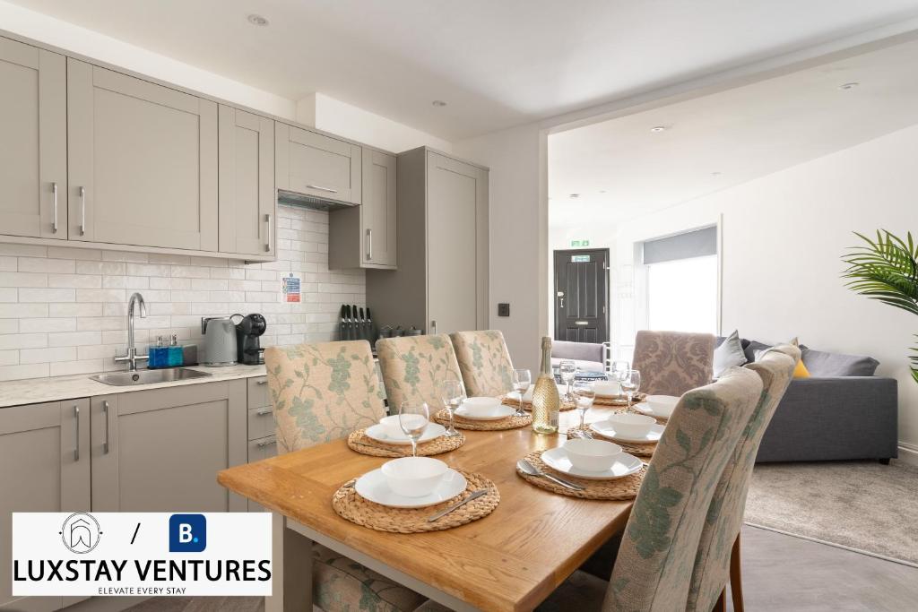 a kitchen and dining room with a wooden table and chairs at Bright and Spacious 2BR Maisonette Sleeps 8, Game Room, 5 mins to Brighton Beach and City Centre in Brighton & Hove