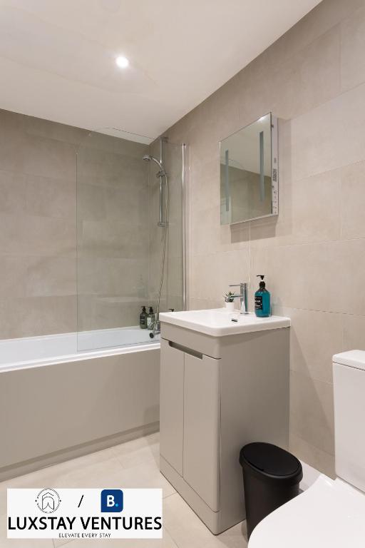 a bathroom with a sink and a tub and a toilet at Bright and Spacious 2BR Maisonette Sleeps 8, Game Room, 5 mins to Brighton Beach and City Centre in Brighton & Hove