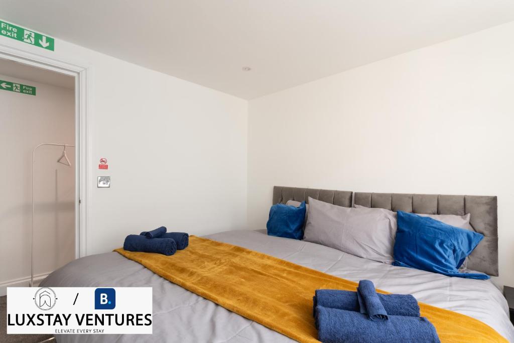 a bedroom with a bed with blue towels on it at Bright and Spacious 2BR Maisonette Sleeps 8, Game Room, 5 mins to Brighton Beach and City Centre in Brighton & Hove