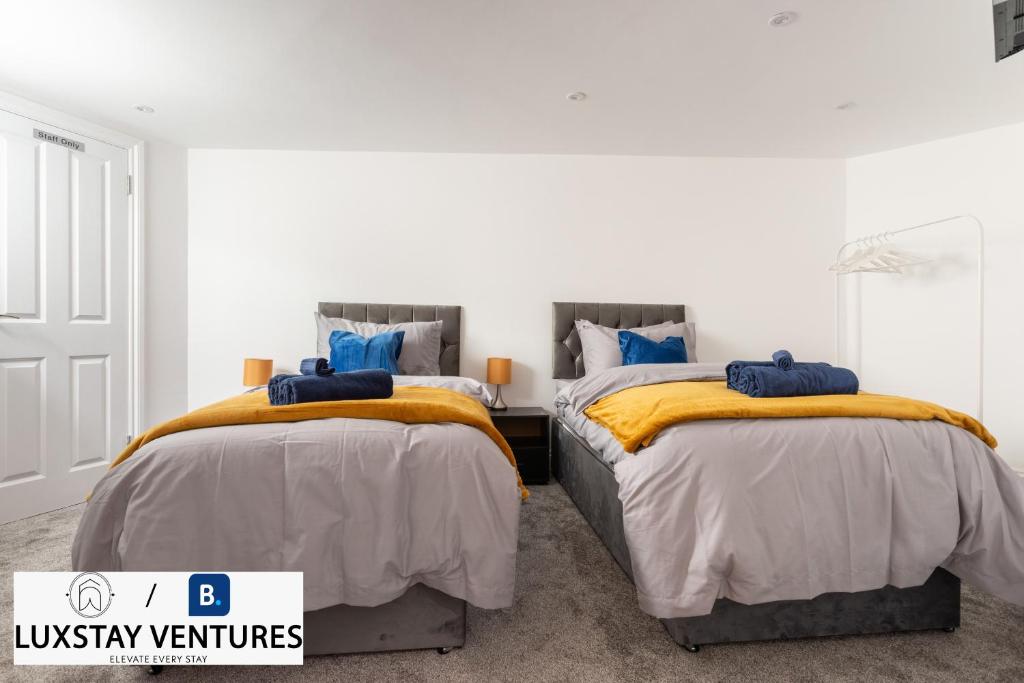 two beds sitting next to each other in a bedroom at Bright and Spacious 2BR Maisonette Sleeps 8, Game Room, 5 mins to Brighton Beach and City Centre in Brighton & Hove