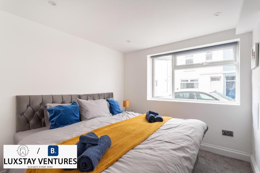 a bedroom with a large bed with blue towels on it at Bright and Spacious 2BR Maisonette Sleeps 8, Game Room, 5 mins to Brighton Beach and City Centre in Brighton & Hove