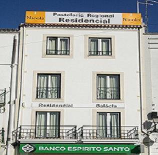 Biały budynek z znakiem na górze w obiekcie Hotel Salatia w mieście Alcácer do Sal