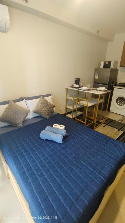 a blue bed in a room with a kitchen at Be Housed Studio Bldg 302 in Lapu Lapu City