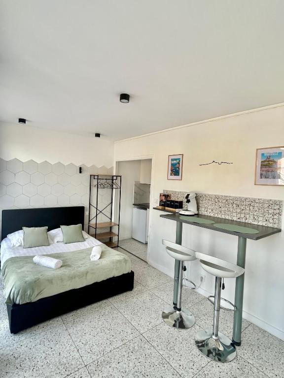 - une chambre avec un lit, une table et un tabouret dans l'établissement Studio devant la gare Saint-Charles, à Marseille