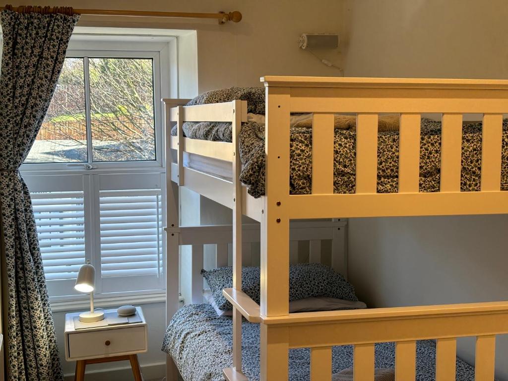a bedroom with a bunk bed and a window at Juliet Cottage, late Georgian treasure, charming, cosy and historic, only a short walk to Alnwick Castle in Alnwick