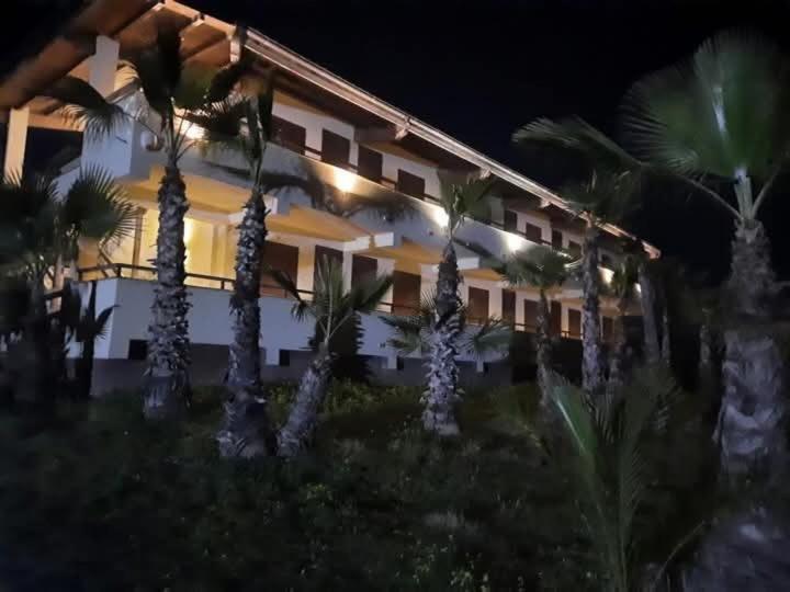 Un edificio con palmeras delante. en home SIKAN casa al mare Licata, en Butera