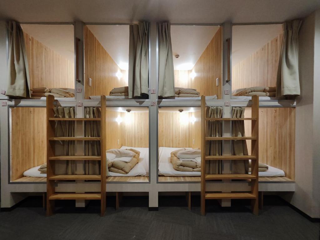 a room with three bunk beds in a room at KOREGA ! Hostel Osaka Namba in Osaka