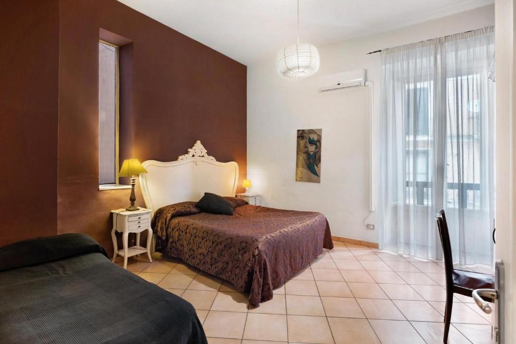 sypialnia z 2 łóżkami i dużym oknem w obiekcie B&B Verdi w mieście Salerno