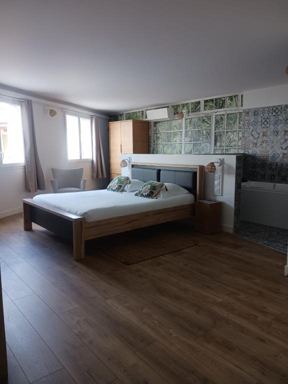 - une grande chambre avec un grand lit et du parquet dans l'établissement Cotinga, à Villars-les-Dombes