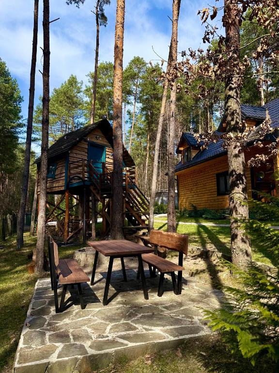 stół piknikowy i ławki przed kabiną w obiekcie Domek w lesie nad zalewem w mieście Chańcza