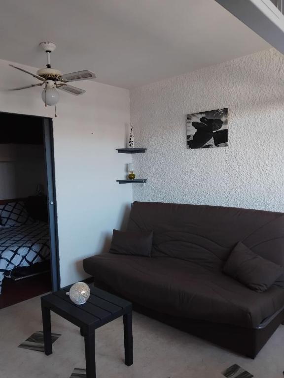 un salon avec un canapé et un ventilateur de plafond dans l'établissement STUDIO Bis - PLAGE, à Port-la-Nouvelle
