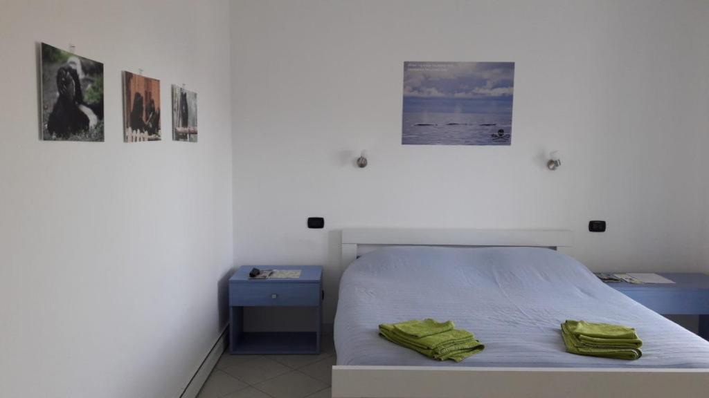 a bedroom with a bed with two green towels on it at B&B casa KaRa in Dolceacqua