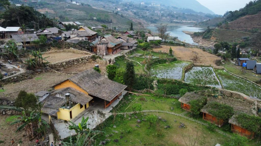 an aerial view of a village with a river at Cha Ta Homestay & Trekking Tour Sa Pa in Sa Pa