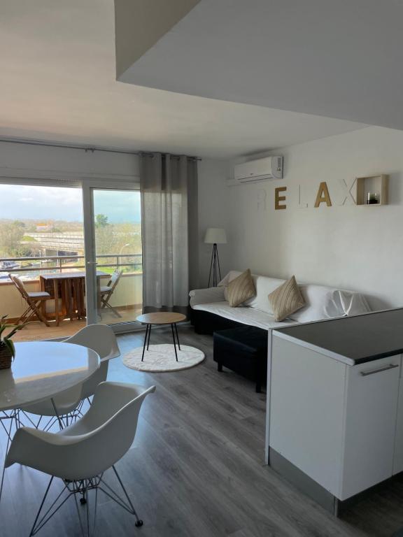a living room with a bed and a table and chairs at Oasis en Roses - Santa Margarita in Empuriabrava