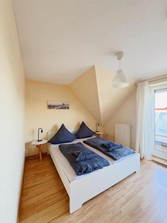 a bedroom with a large bed with blue pillows at Ferienwohnung KÖÖK I - echter Inselblick in Neuharlingersiel