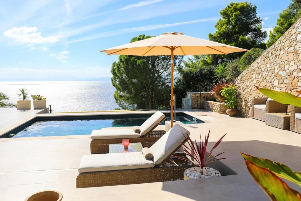 una piscina con sombrilla y tumbonas y una piscina en Villa Fanari, en Kanapitsa