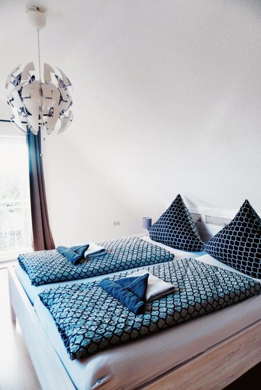 a bedroom with a bed with blue pillows at Ferienwohnung KÖÖK II - Der Strand ist zum greifen nah.... in Neuharlingersiel