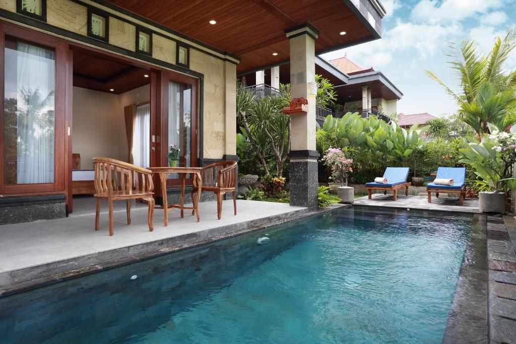 Casa con piscina, mesa y sillas en Dewi Sri Private Villa en Ubud