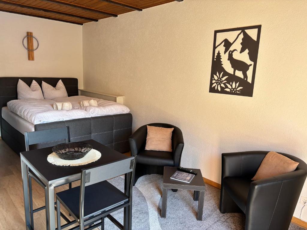 una stanza con un letto, un tavolo e delle sedie di Auberge Les Rangs a Conthey