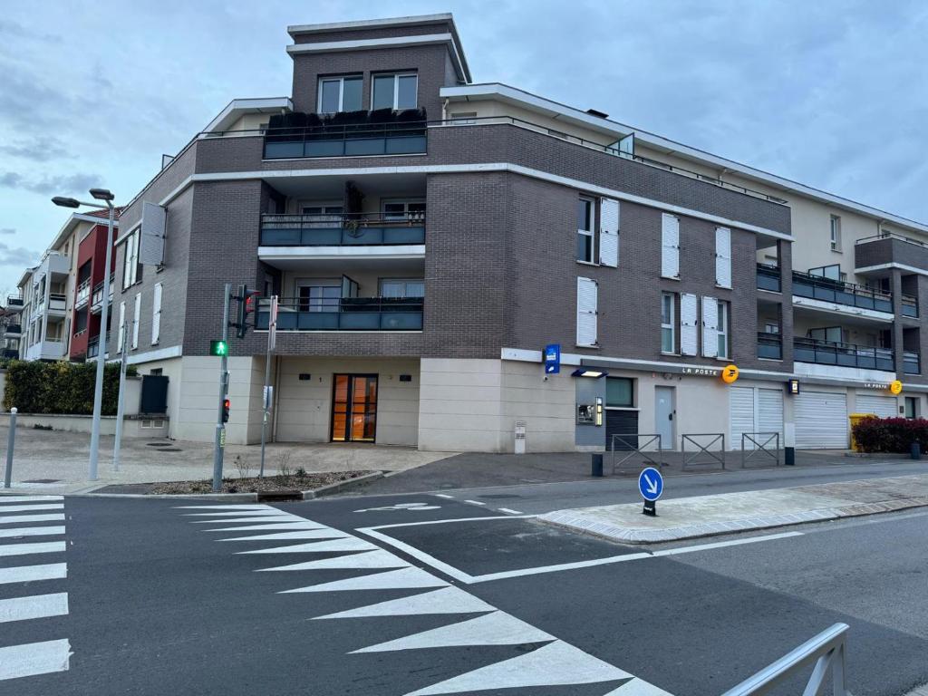 un bâtiment situé dans une rue avec un passage en avant dans l'établissement Appartement entièrement meublé de 57m Chanteloup les vignes Centre ville, à Chanteloup-les-Vignes