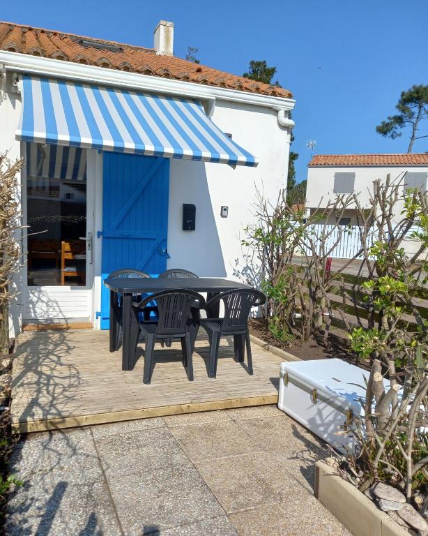 un patio avec une table et des chaises devant une maison dans l'établissement Atlantique 165, à La Faute-sur-Mer