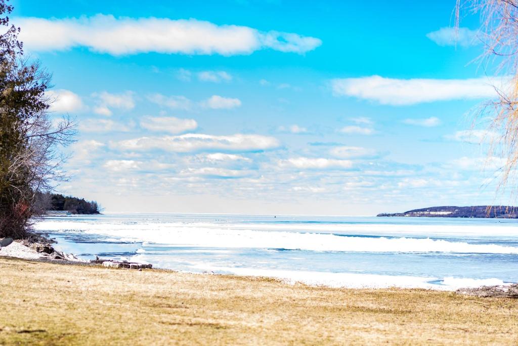 a beach with the ocean on a cloudy day at Beach Harbor Resort in Sturgeon Bay
