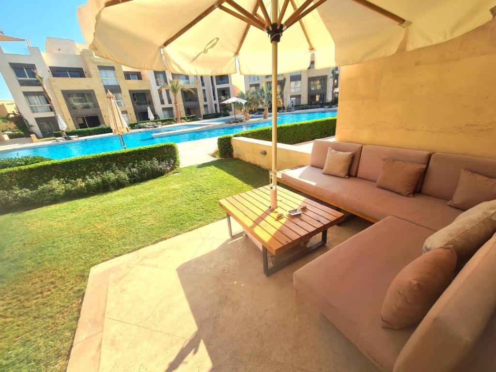 a living room with a couch and an umbrella at Fabulous Sea view 1 BR & private Garden to the pool at Mangroovy in Hurghada