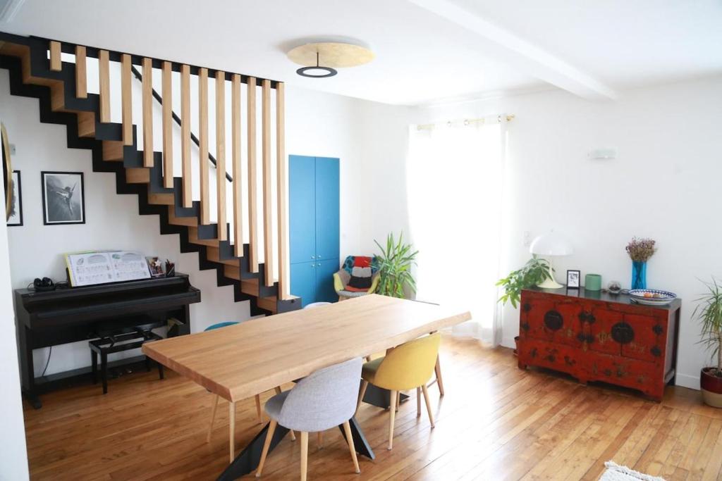 une salle à manger avec une table et un piano dans l'établissement Beautiful Duplex, à Issy-les-Moulineaux