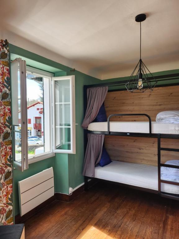 two bunk beds in a room with a window at Gite Compostella in Saint-Jean-Pied-de-Port