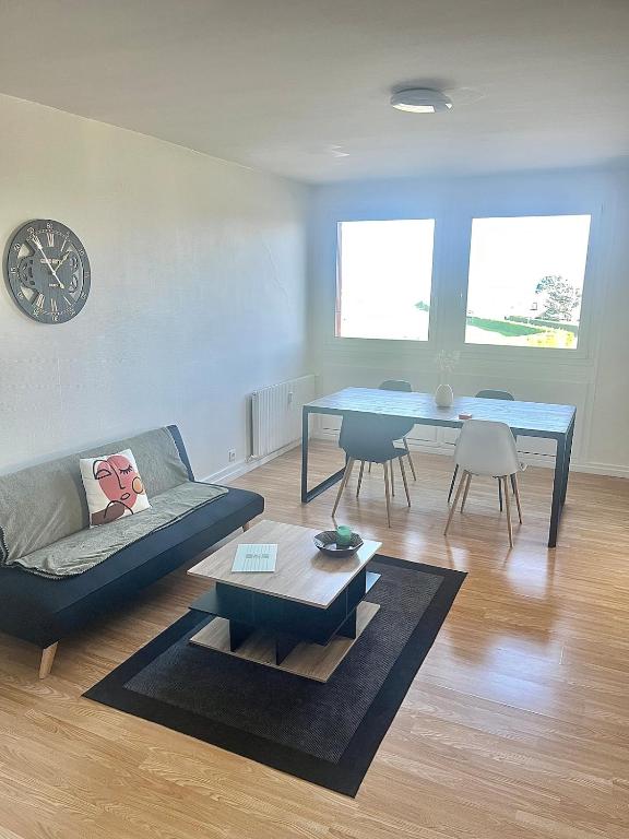 un salon avec un canapé et une table dans l'établissement Ma parenthèse, à Dieppe