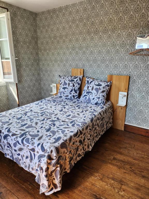 a bedroom with a bed with a blue and white comforter at Gite Compostella in Saint-Jean-Pied-de-Port