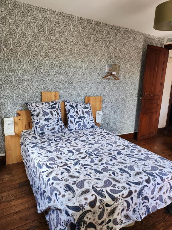 a bedroom with a bed with a blue and white comforter at Gite Compostella in Saint-Jean-Pied-de-Port