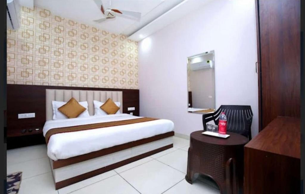 Una habitación de hotel con una cama grande y un escritorio. en Skyla Hotel, en Zirakpur