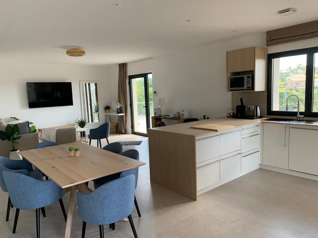 une cuisine et un salon avec une table et des chaises dans l'établissement Superbe appartement 4 Pièces - Accès Piscine, à Cagnes-sur-Mer