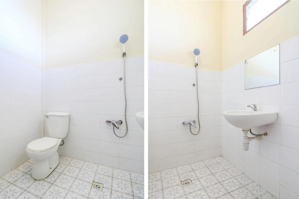 a white bathroom with a toilet and a sink at OYO 2184 Nan Berlian Inn in Legian