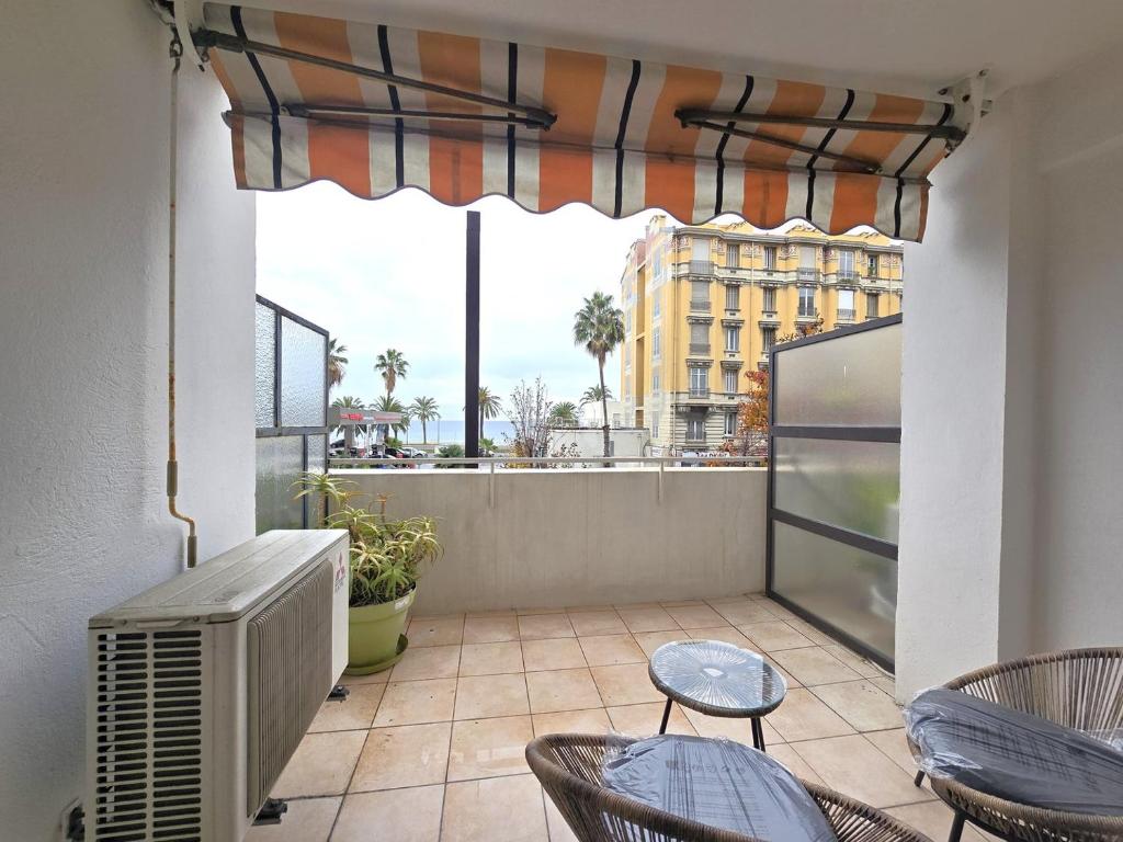 un balcon avec des chaises et une fenêtre avec vue sur une ville dans l'établissement Large T2 50m from the beaches, à Nice