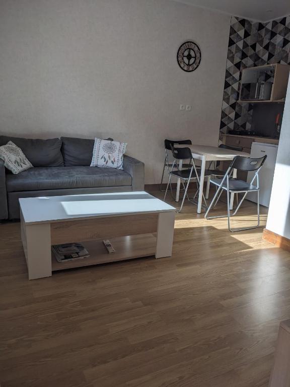 un salon avec un canapé et une table dans l'établissement Appartement et salle de jeu, à Saint-Claude