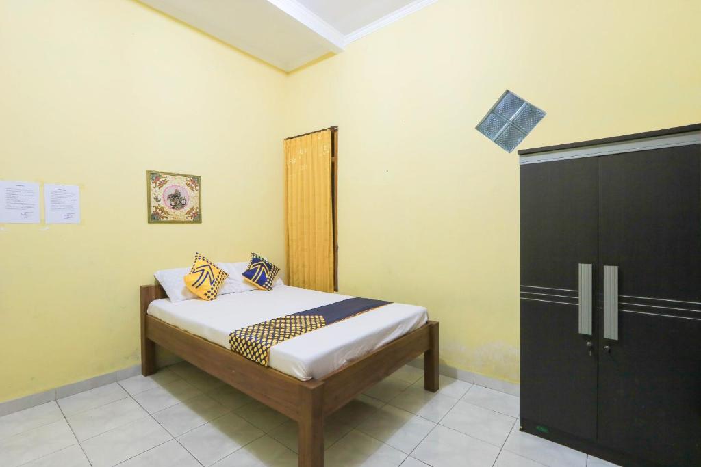 Postel nebo postele na pokoji v ubytování OYO 2440 Wallet Family Residence Syariah