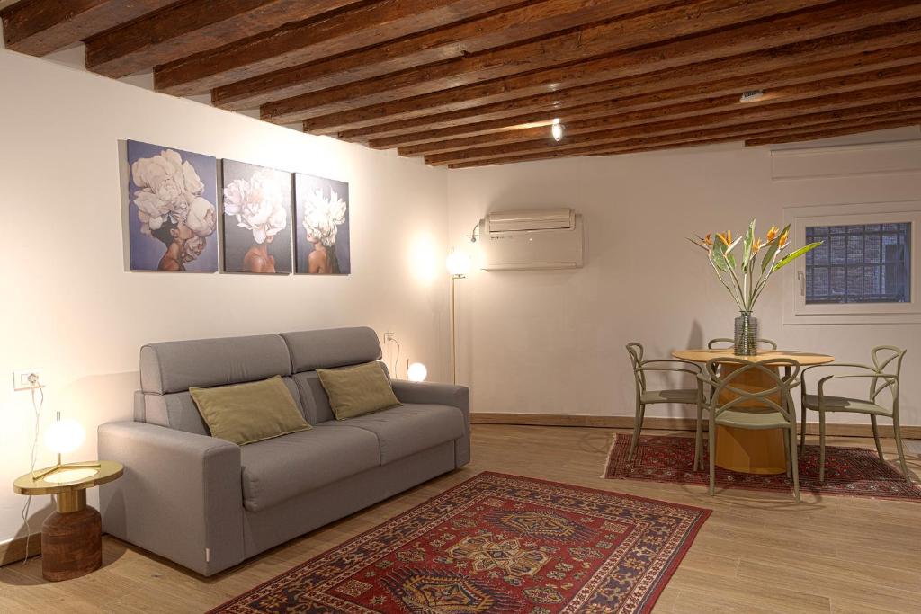 un soggiorno con un divano e un tavolo di Mascherone Apartment a Venezia