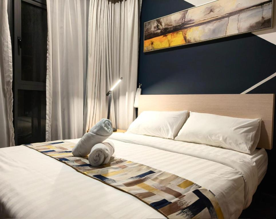 DonggongonにあるKavenue 2-Bedroom 4 pax BY CSEの壁に絵が飾られたベッドのある寝室