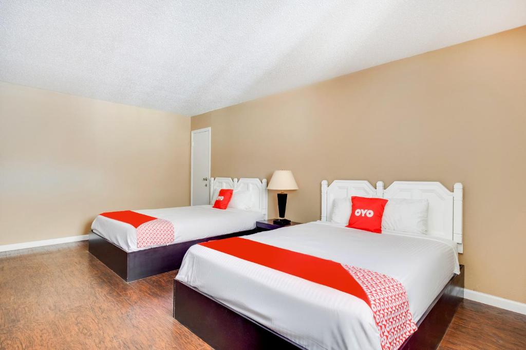 a bedroom with two beds with red and white sheets at OYO Hotel Elk City OK Route 66 in Elk City