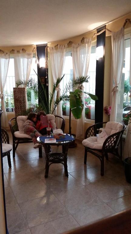 une personne assise sur un canapé dans un salon dans l'établissement Hotel Lozite, à Sozopol