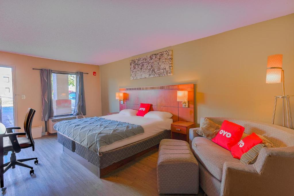un dormitorio con una cama y un sofá en OYO Hotel Brownsville TN I-40, en Brownsville