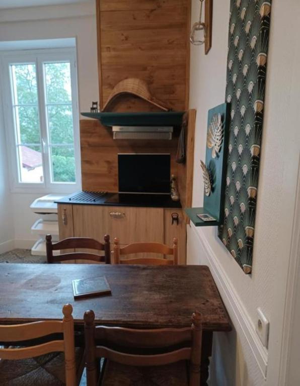 a kitchen with a wooden table and chairs and a kitchen with a window at Gite Compostella in Saint-Jean-Pied-de-Port